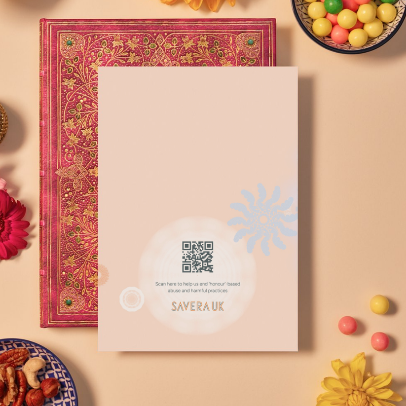 Back of a card with a soft peach background featuring faint mandala patterns made of swirling and circular geometric shapes in pastel blue, white, and orange tones. At the bottom center, a glowing white mandala contains a QR code above the text: ‘Scan here to help us end ‘honour’-based abuse and harmful practices.’ Below the text is the orange geometric logo ‘SAVERA UK.’