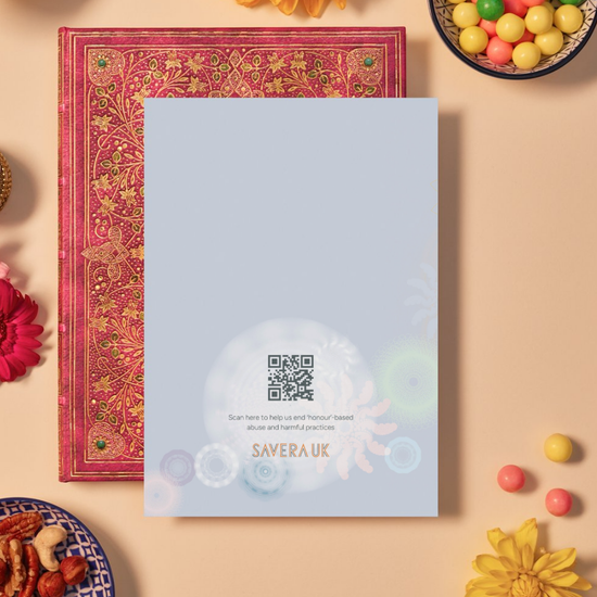 Back of a card with a soft blue background featuring faint mandala patterns made of circular and floral geometric shapes in pastel shades of blue, peach, and green. At the bottom center, a glowing white mandala contains a QR code above the text: ‘Scan here to help us end ‘honour’-based abuse and harmful practices.’ Below the text is the orange geometric logo ‘SAVERA UK.'