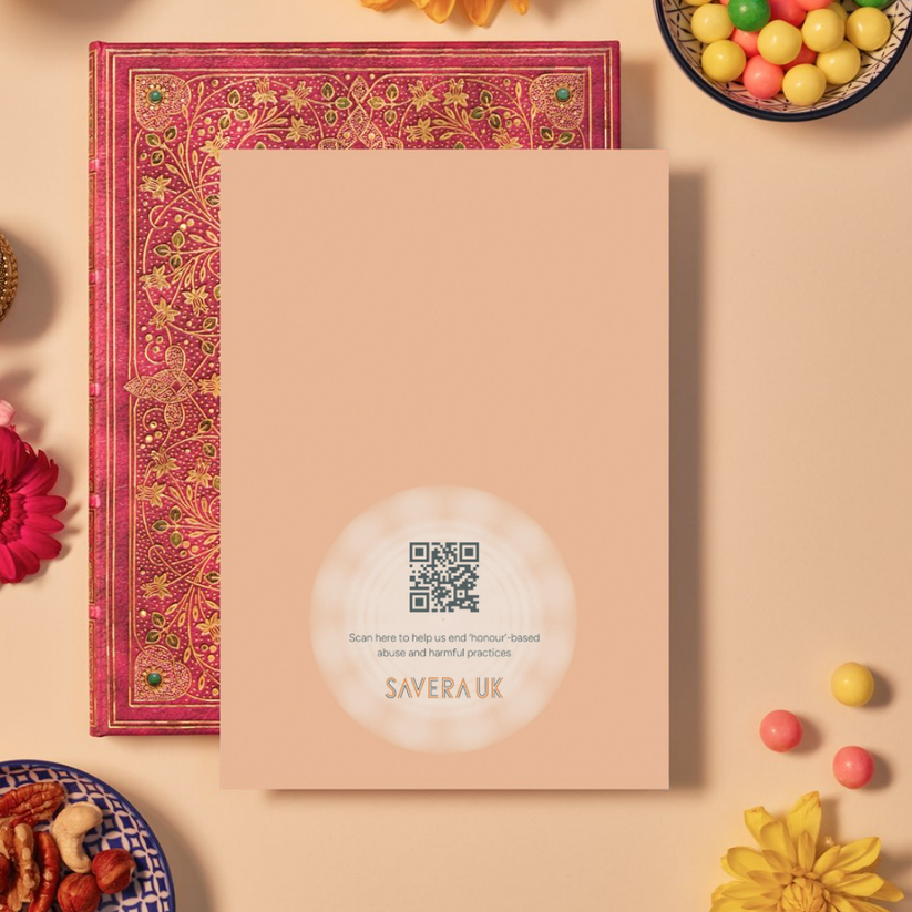 Back of a card with a warm peach background featuring a subtle circular mandala pattern radiating from the bottom center. In the center of the mandala is a QR code above the text: ‘Scan here to help us end ‘honour’-based abuse and harmful practices.’ Below the text is the orange geometric logo ‘SAVERA UK.’