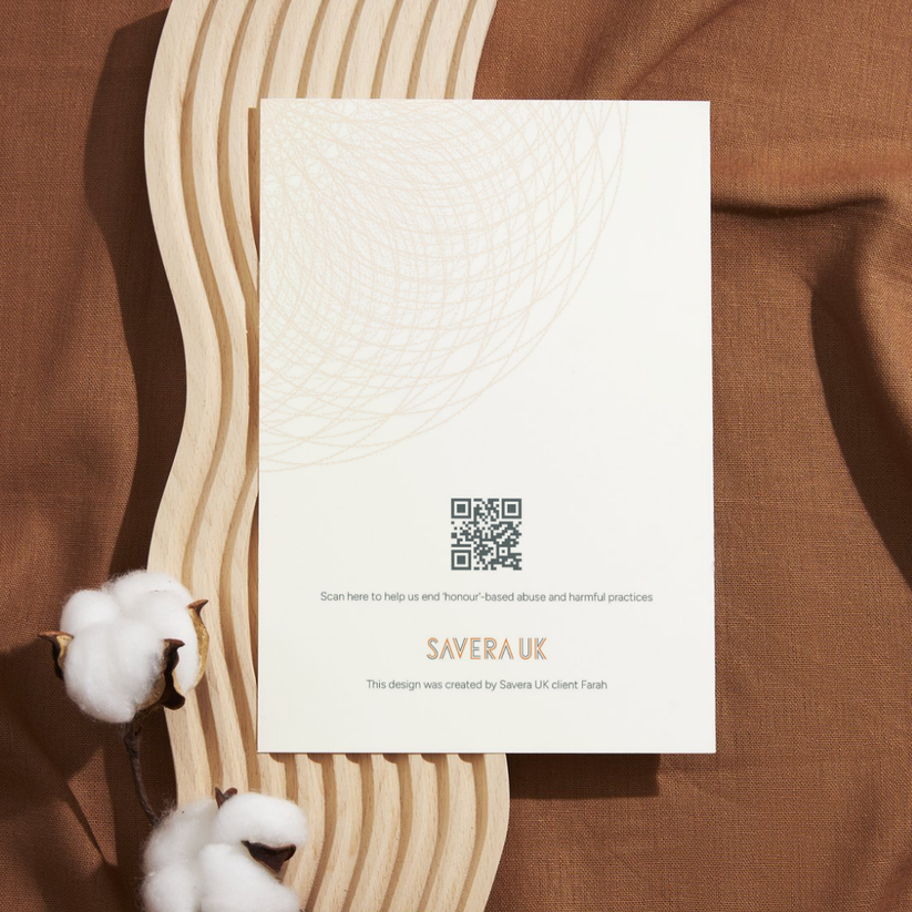 The back of the card features a subtle golden mandala design near the top. A centred QR code is placed above the text: “Scan here to help us end ‘honour’-based abuse and harmful practices.” Beneath is the Savera UK logo, followed by the credit: “This design was created by Savera UK client Farah.” The layout is elegant and understated, highlighting the powerful contribution of a survivor and the purpose behind the card.