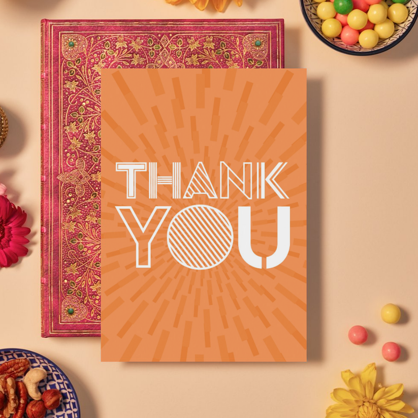 Card with bold white text reading ‘THANK YOU’ in a mix of outlined and striped geometric fonts. The background is a bright orange featuring a mandala-like burst pattern made of radiating rectangular shapes, creating a dynamic and energetic sense of gratitude and appreciation.