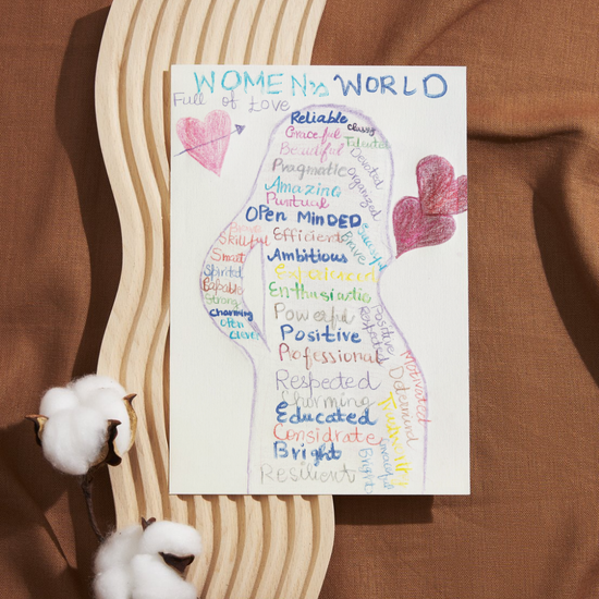 A colourful, hand-drawn silhouette of a woman filled with empowering words like “Resilient,” “Educated,” and “Open Minded.” Above, it reads “WOMEN in a WORLD Full of Love,” with two pink hearts sketched nearby. The design celebrates strength and individuality, created with warmth and hope.